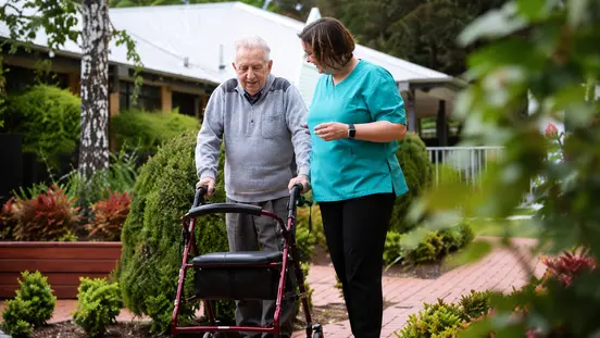 Aged care worker supporting an elderly person in Australia